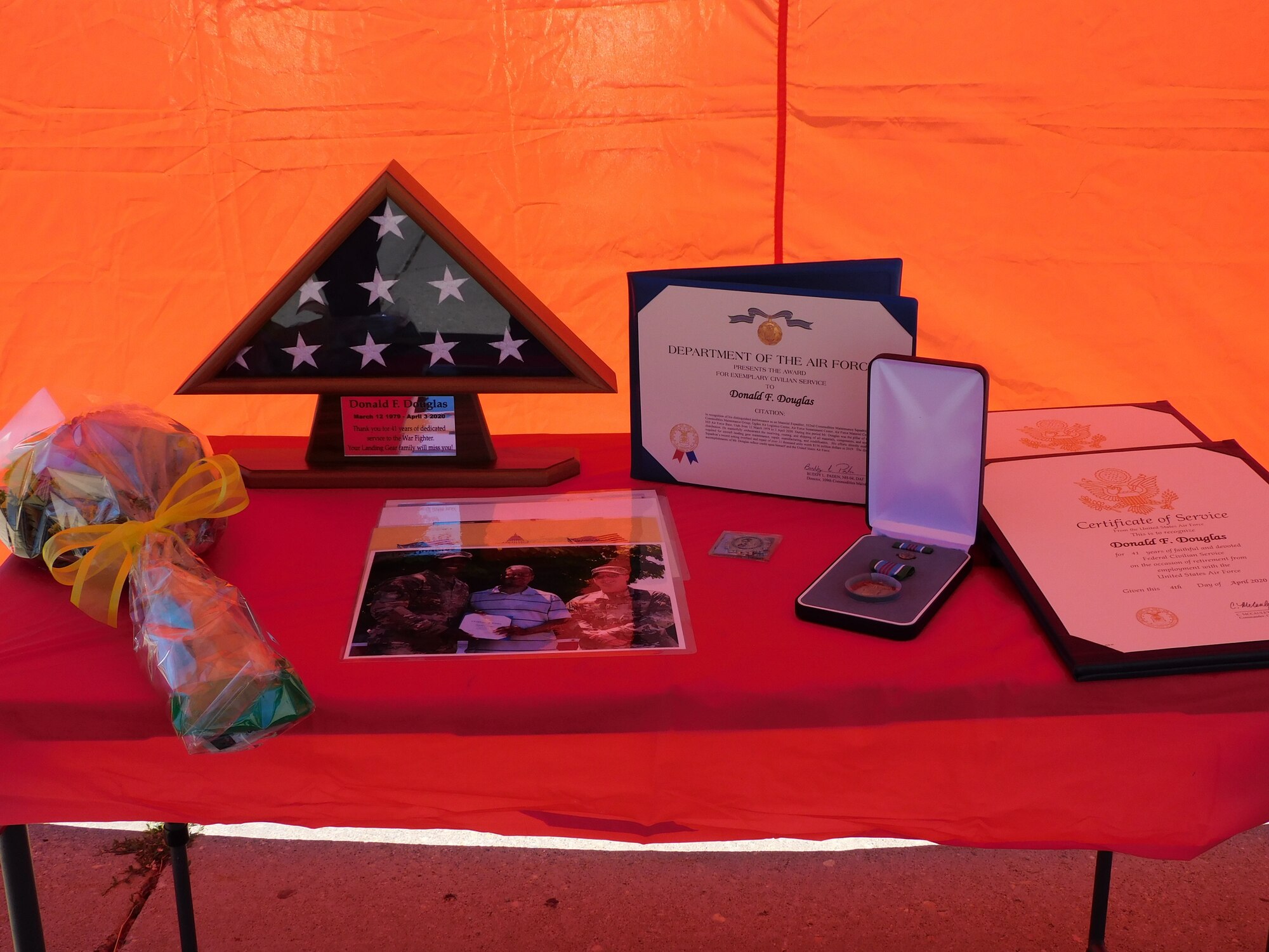 The certificates, award, flag, coin and pin presented to Donald F. Douglas sit upon a table at his retirement ceremony.