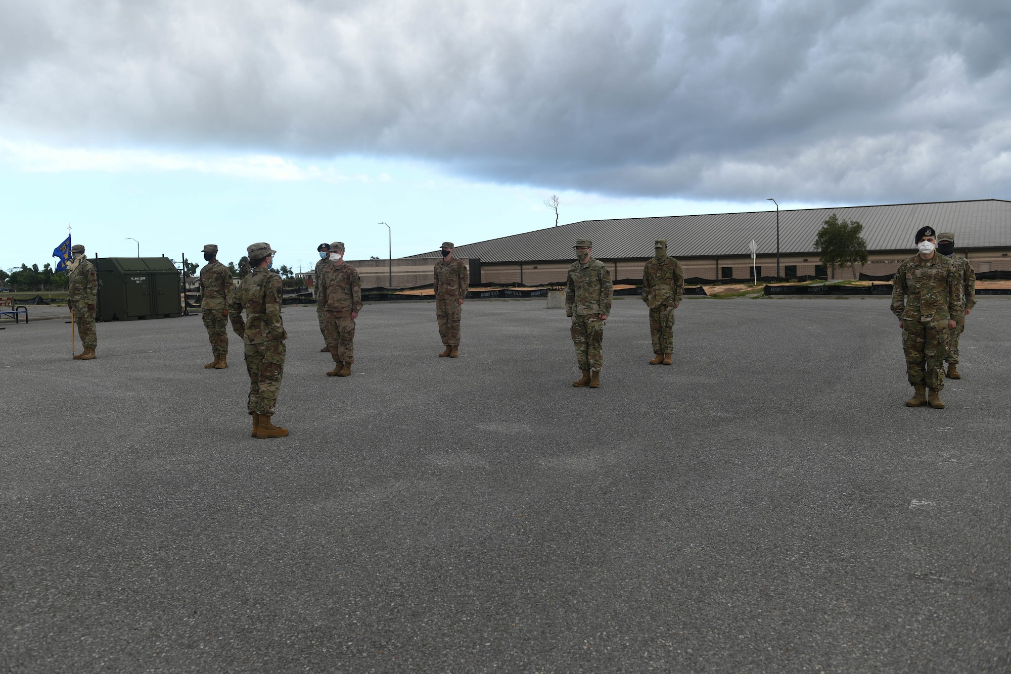 Students stand outside in formation wearing face coverings during Airman Leadership School