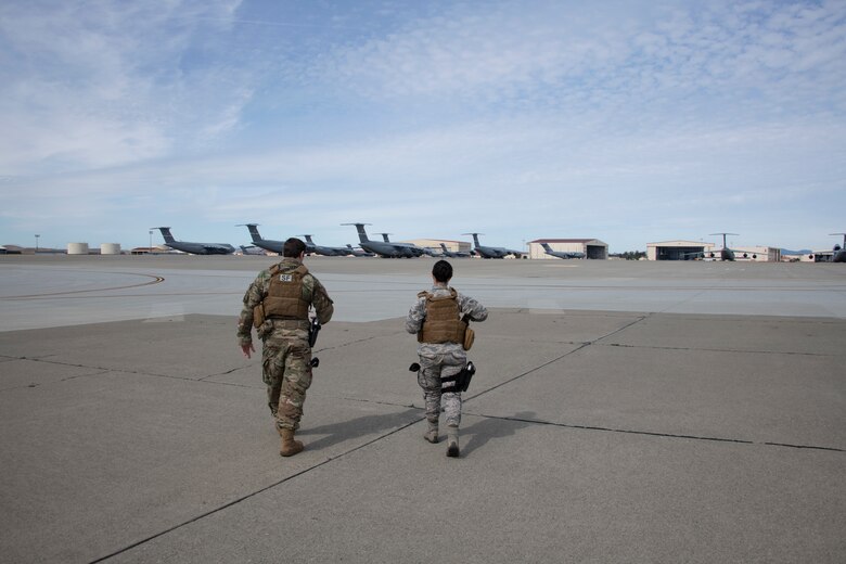 U.S. Air Force Staff Sgt. Brenden Rinehart, left, 60th Security Forces Squadron patrolman, and Airman 1st Class Stephanie DaSilva, 60th SFS installation entry controller, perform a security check May 16, 2020, on the flight line at Travis Air Force Base, California. The flight line is where all three airframes assigned to the base -- the C-17 Globemaster III, C-5M Super Galaxy and KC-10 Extender -- are prepared to fly missions. (U.S. Air Force photo by Tech. Sgt. James Hodgman)