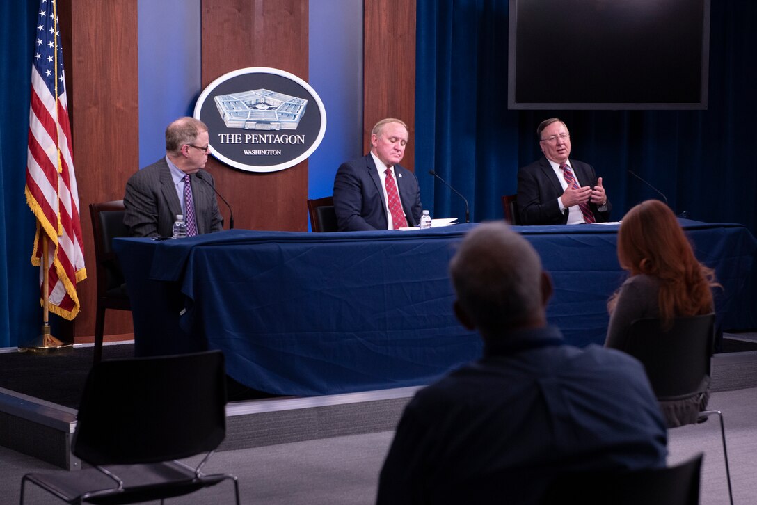 Man answers question during a socially distant briefing.