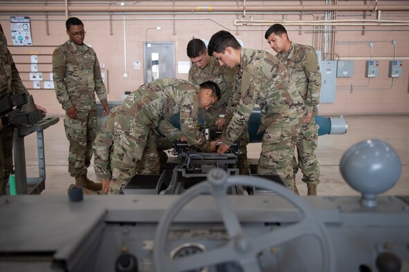 Airmen learn to disassemble and inspect a missile loading adapter