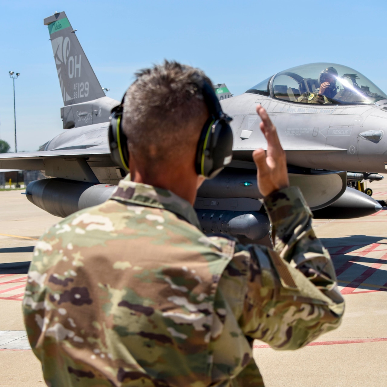 A service member directs a jet.
