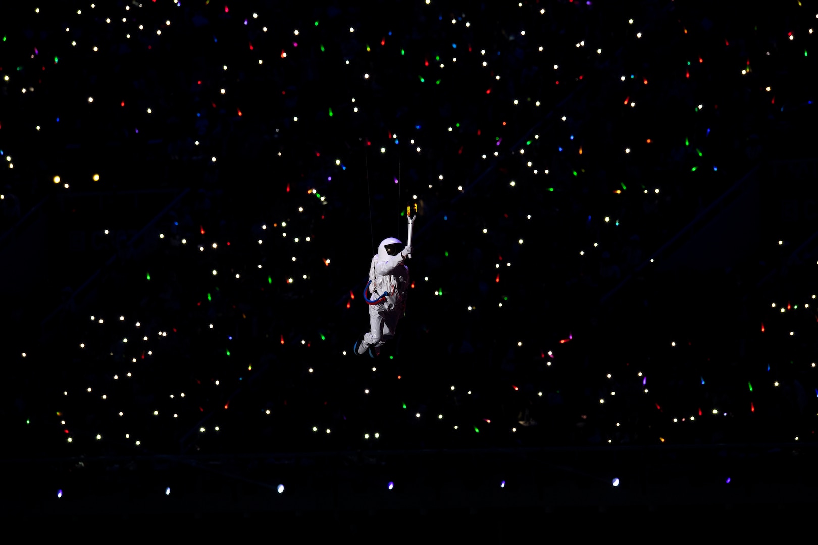 An entertainer floats by wire past a crowd holding light sticks during opening ceremonies for the 2019 CISM Military World Games in Wuhan, China Oct. 18, 2019. Teams from more than 100 countries will compete in dozens of sporting events through Oct. 28. (DoD photo by EJ Hersom)