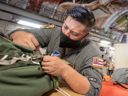 Tech. Sgt. Josh Moracco, 204th Airlift Squadron loadmaster adjusts the straps on Pararescuemen equipment loaded onto a C-17 Globemaster III, May 26, 2019, Joint Base-Pearl Harbor-Hickam.