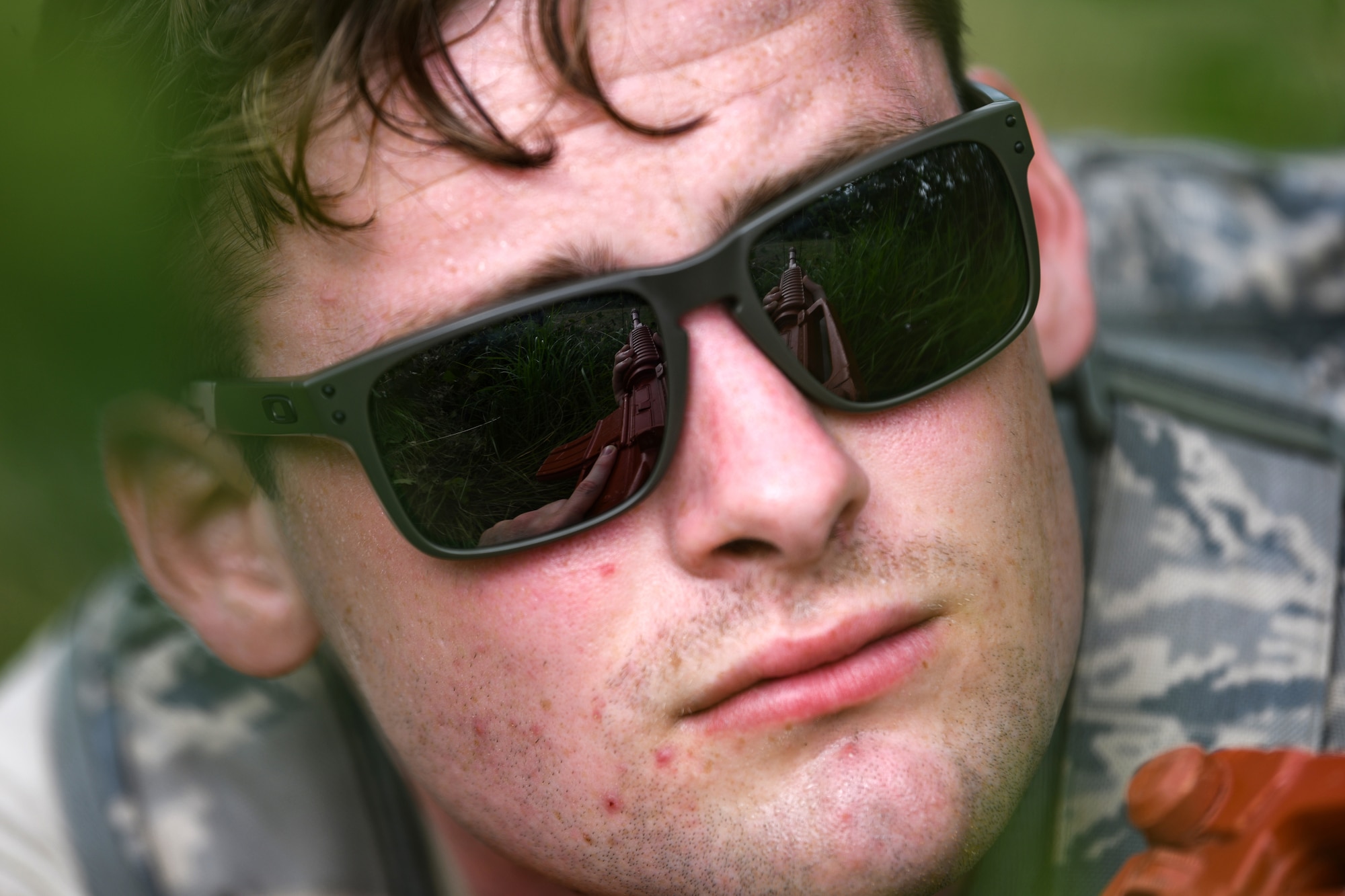 U.S. Air Force Airman 1st Class Declan Ward, 31st Security Force Squadron monitoring facility operator hides in the grass during Operation Porcupine, June 30, 2020 at Osoppo, Italy. The 31st SFS maintains installation force protection during peacetime and wartime operations within eight separate base areas. (U.S. Air Force photo by Airman 1st Class Ericka A. Woolever)