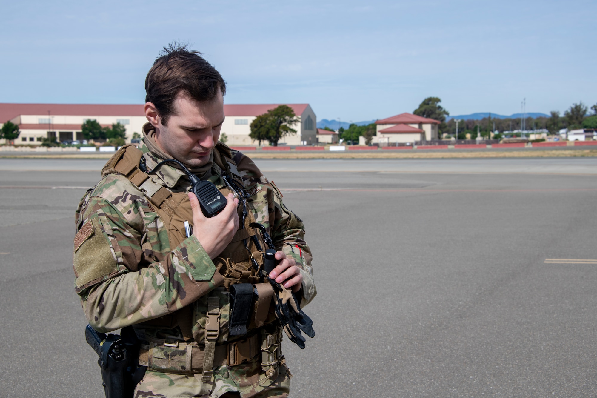 U.S. Air Force Staff Sgt. Brenden Rinehart, 60th Security Forces Squadron patrolman, calls in a perimeter check using his mobile radio May 16, 2020, on the flight line at Travis Air Force Base, California. As a security forces Airman at Travis AFB, Rinehart supports missions for the 60th Air Mobility Wing, 621st Contingency Response Wing and the Air Force Reserve’s 349th Air Mobility Wing. (U.S. Air Force photo by Tech. Sgt. James Hodgman)