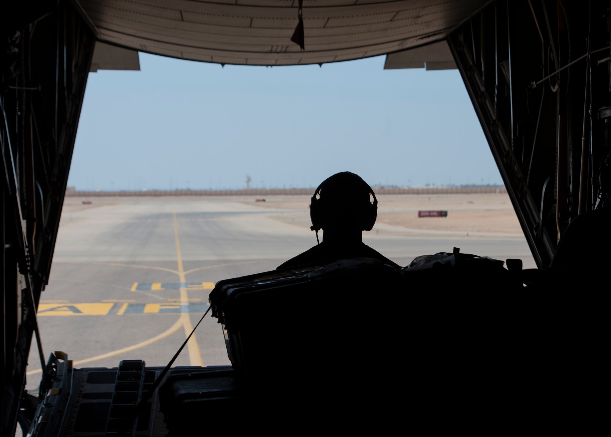 looks out the rear of a C-130