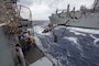 Sailors aboard the Ticonderoga-class guided-missile cruiser USS Antietam (CG 54) prepare to receive a fuel line during a replenishment-at-sea with the Lewis and Clark-class dry cargo ship USNS Carl Brashear (T-AKE 7)