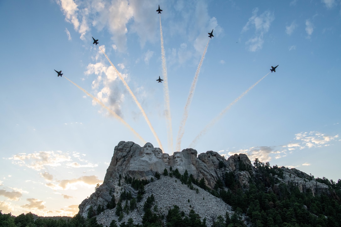 Six military aircraft fly over Mount Rushmore.