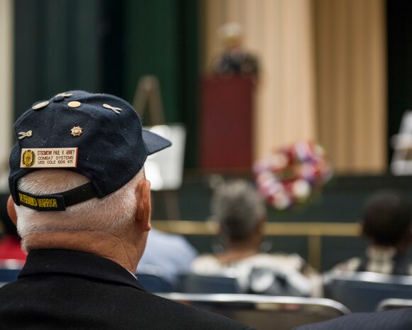 Retired Master Chief Sonar Technician Paul Abney, a USS Cole survivor, listens to Adm. Christopher Grady, commander of U.S. Fleet Forces Command, address attendees at a remembrance ceremony.