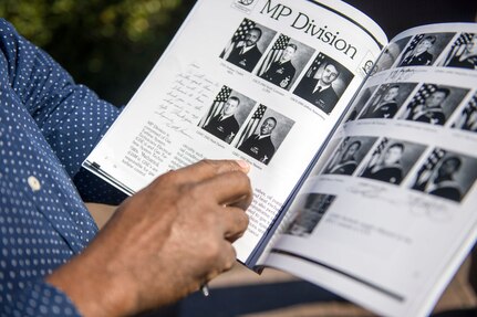 Retired Lt. Elroy Newton points to his photo in his cruise book from the guided-missile destroyer USS Cole (DDG 67).