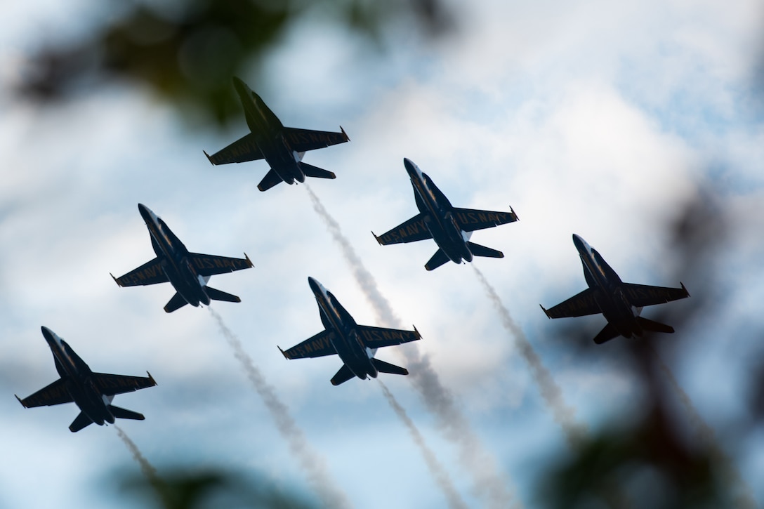 A group of military aircraft fly in formation.