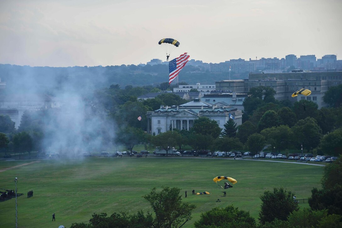 A parachutist carrying an American flag descends near the White House.