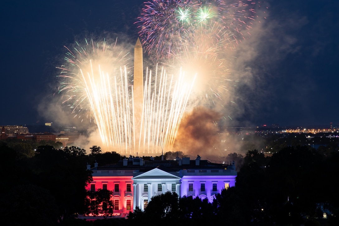 Fireworks illuminate the night sky over the White House and the Washington Monument.