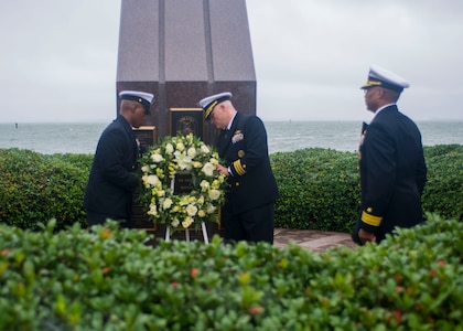 Cmdr. David Wroe, commanding officer of the guided-missile destroyer USS Cole (DDG 67), and Command Master Chief Michale Leggett place a wreath at the USS Cole Memorial as Rear Adm. Jessie A. Wilson, Jr., commander, Naval Surface Force Atlantic, pays his respects.