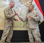 U.S. Marine Brig. Gen. Bill Seely (right), the departing commander of Combined Joint Task Force-Operation Inherent Resolve’s Task Force Iraq, passes the ceremonial “swagger stick” to U.S. Marine Brig. Gen. Ryan Rideout, incoming Military Advisory Group director, signifying the transition of Task Force Iraq into the Military Advisory Group.