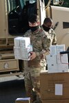 North Carolina Army National Guard Sgt. Brandon Eller, assigned to the 258th Engineer Battalion, loads personal protective equipment for delivery to public and charter school nurses in surrounding counties at a warehouse in Central N.C., June 29, 2020.