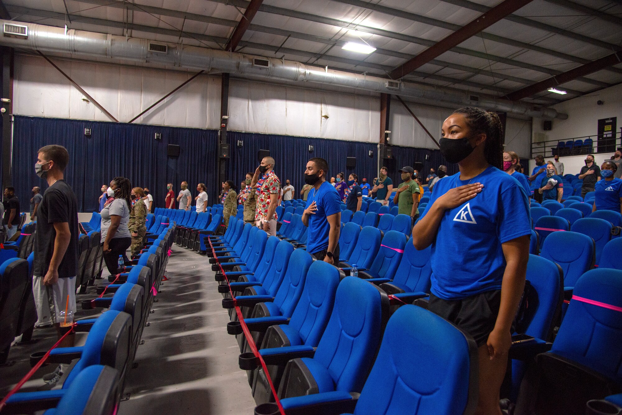 Service members stand for the National Anthem at the 4th of July Celebration’s Talent Show, July 4, 2020, Al Udeid Air Base, Qatar. The talent show was one of multiple events hosted by the 379th Expeditionary Force Support Squadron to celebrate the 4th of July following strict Center for Disease Control guidance to minimize exposure.