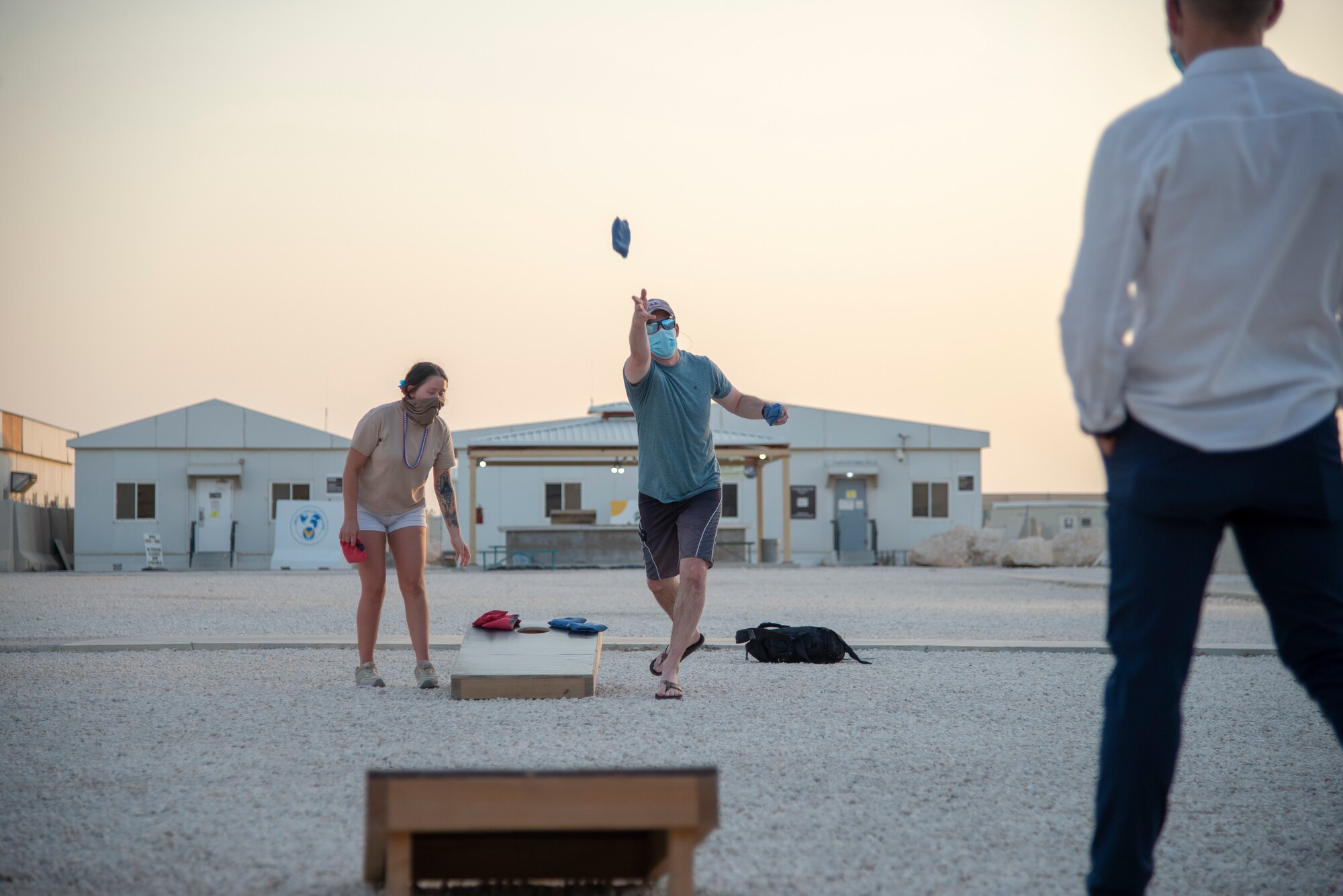 Attendees of the 4th of July celebration play in a bean bag toss tournament, July 4, 2020, Al Udeid Air Base, Qatar. Members of the 379th Expeditionary Force Support Squadron put together multiple events for their 4th of July celebration on Independence Day following strict Center for Disease Control guidance.