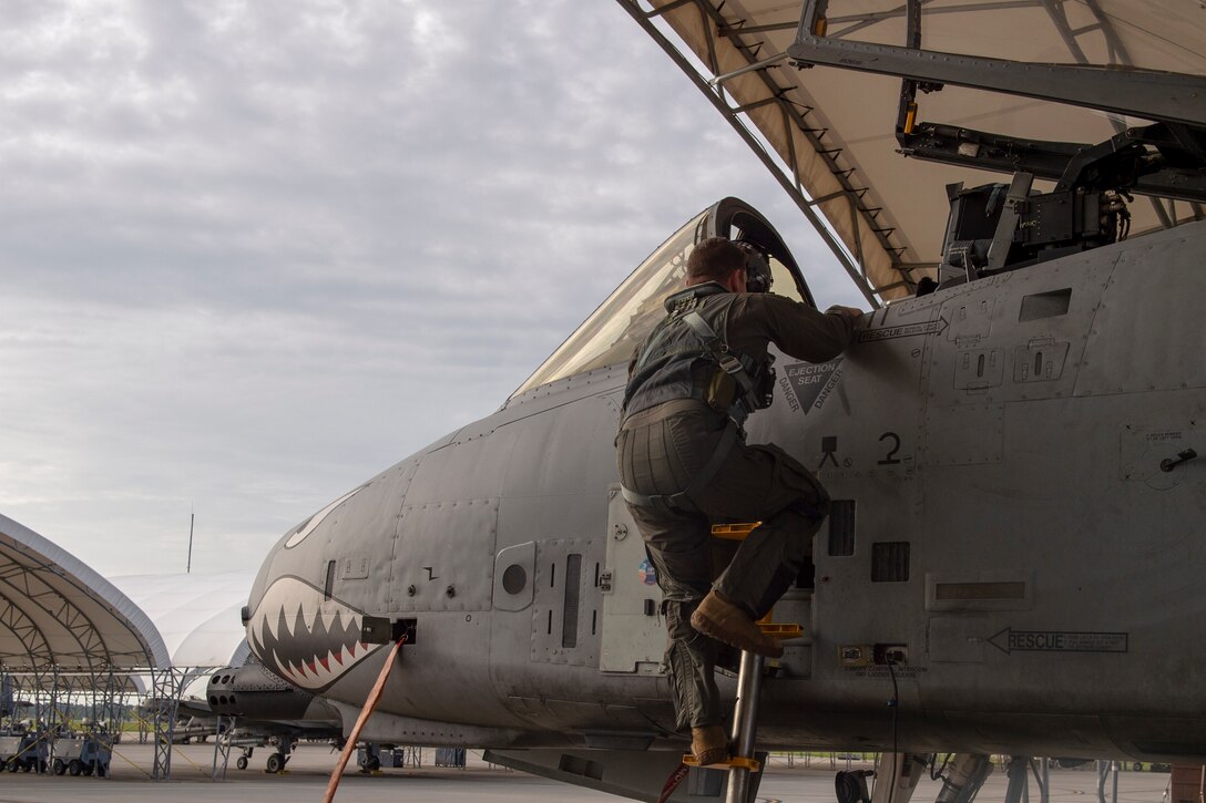 A photo of a pilot climbing into an aircraft