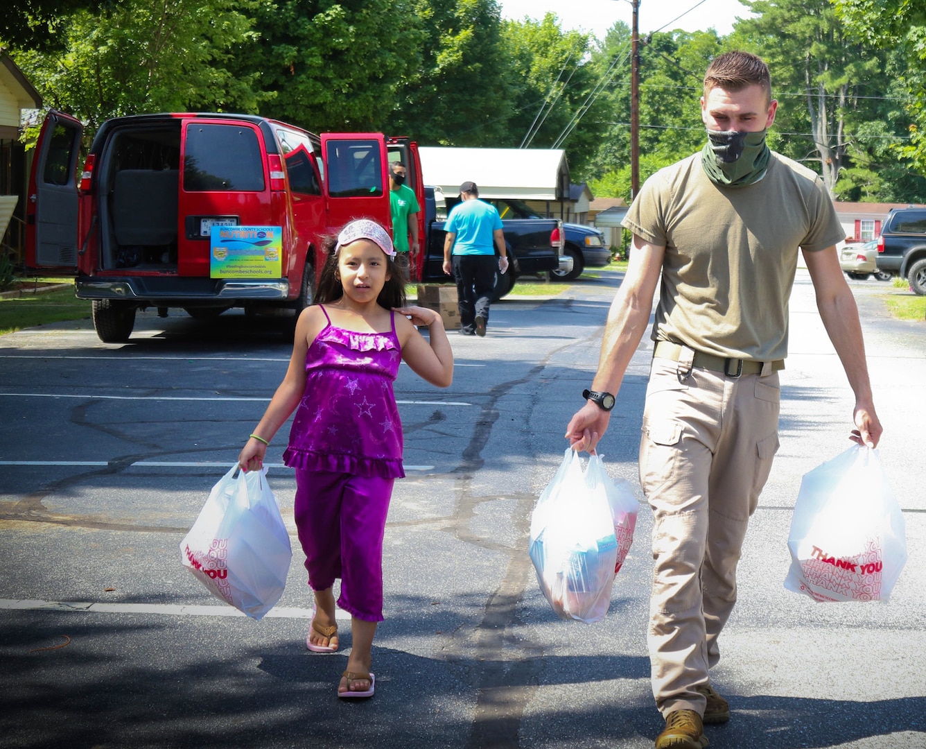 North Carolina Army National Guard Pvt. 1st Class Bennie Kinley (right), assigned to the 875th Engineer Company, helps carry breakfast meals