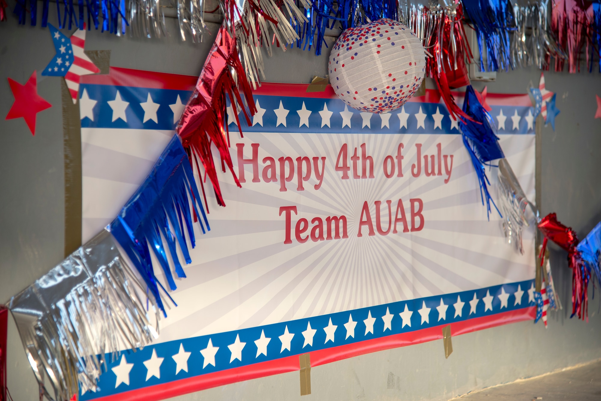 A celebratory sign stands decorated at Memorial Plaza where people gathered to enjoy free music, food and company, July 4, 2020, Al Udeid Air Base, Qatar. Members of the 379th Expeditionary Force Support Squadron put together multiple events for their 4th of July celebration on Independence Day following strict Center for Disease Control guidance.