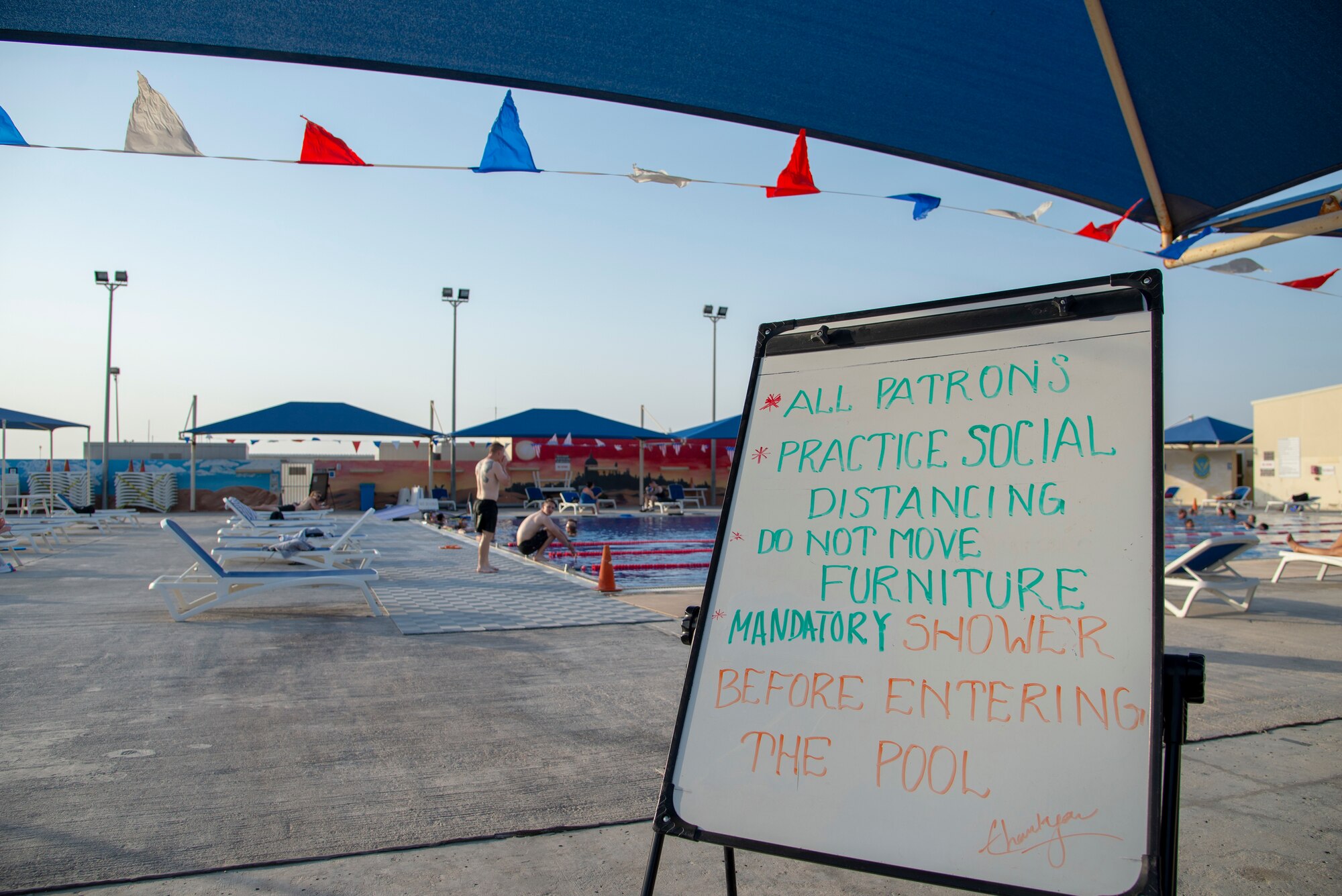 Service members swim in the base pool during an Independence Day event, July 4, 2020, Al Udeid Air Base, Qatar. All patrons at the base pool had to follow social distancing and hygiene measures in an effort to diminish exposure during a pandemic.