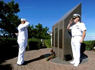 etty Officer 1st Class Miguel Rodriguez, left, and Lt. Benjamin Warner salute during a remembrance ceremony at the Cole Memorial onboard Naval Station Norfolk.