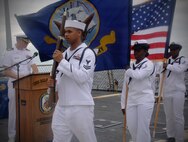 Sailors aboard the guided-missile destroyer USS Cole (DDG 67) parade the colors during a memorial service honoring the 16th year anniversary of the attack on the ship.