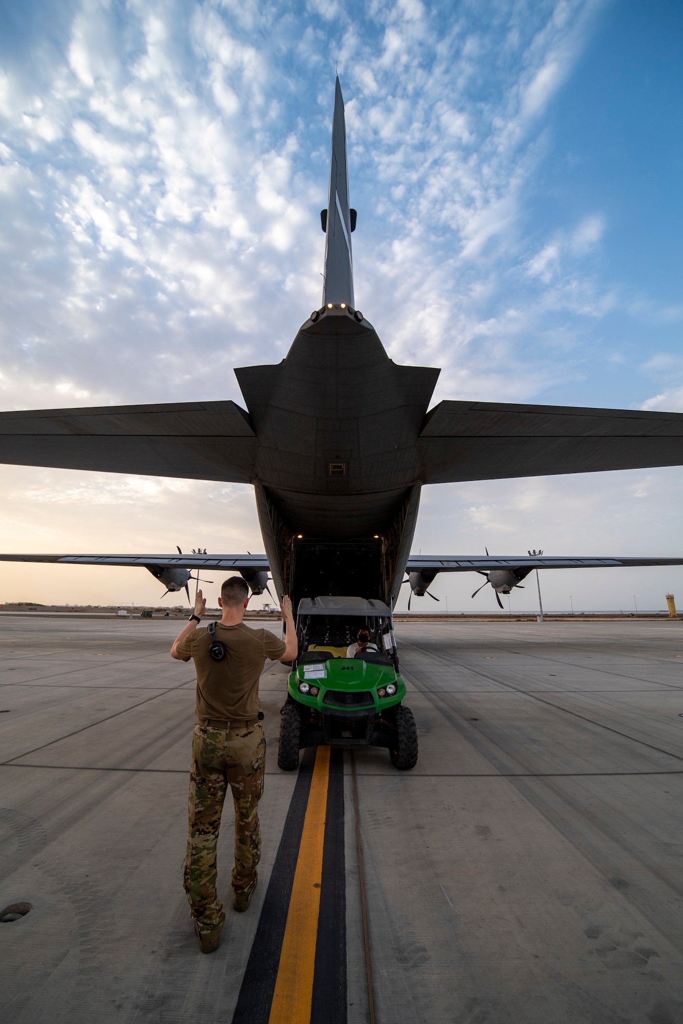 A U.S. Air Force 75th Expeditionary Airlift Squadron (EAS) loadmaster directs a vehicle onto a C-130J Super Hercules at Camp Lemonnier, Djibouti, June 28, 2020. The 75th EAS provides strategic airlift capabilities across the Combined Joint Task Force - Horn of Africa (CJTF-HOA) area of responsibility. (U.S. Air Force photo by Tech. Sgt. Christopher Ruano)