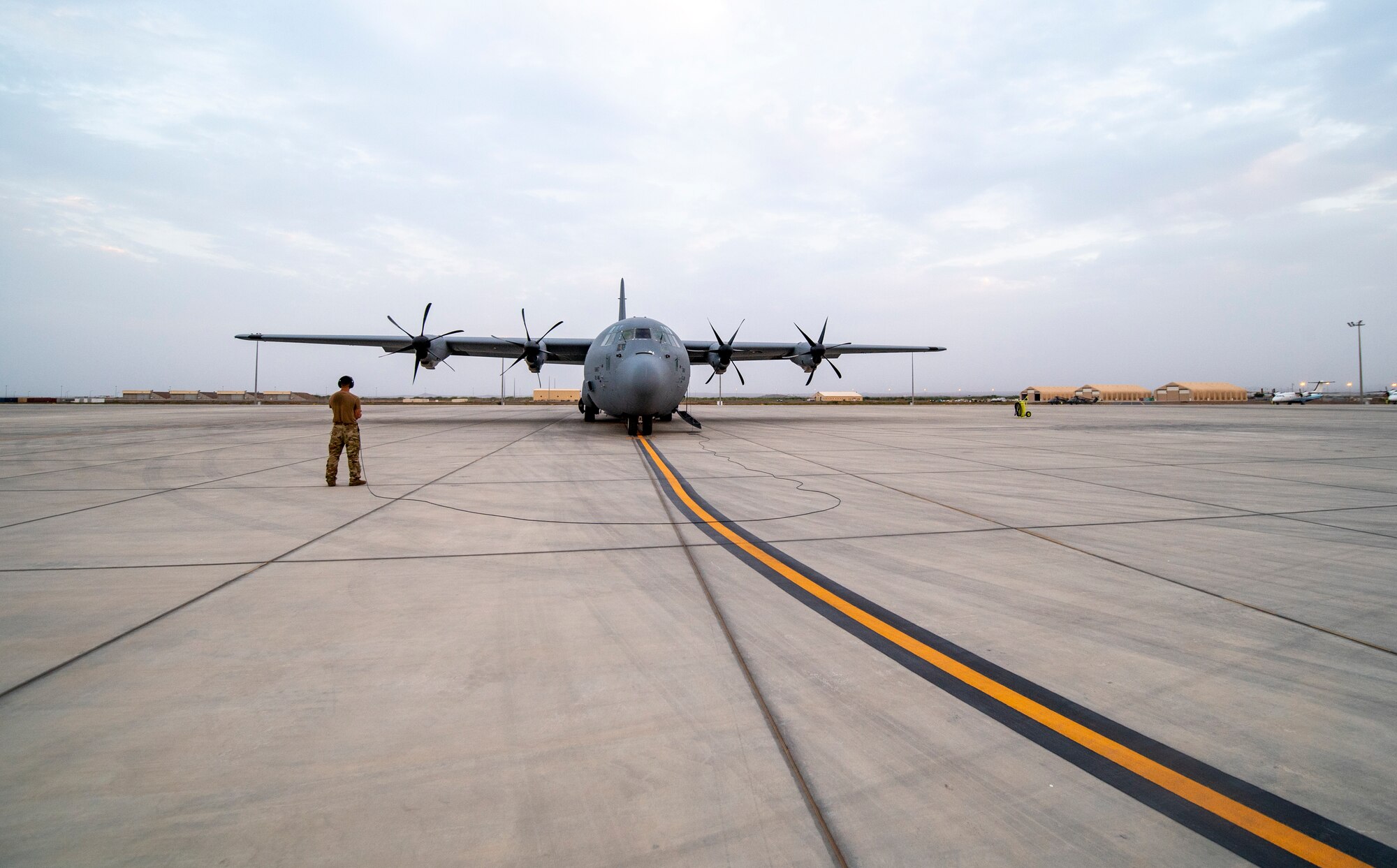 A U.S. Air Force 75th Expeditionary Airlift Squadron (EAS) loadmaster ensures engine start of a C-130J Super Hercules at Camp Lemonnier, Djibouti, June 28, 2020. The 75th EAS provides strategic airlift capabilities across the Combined Joint Task Force - Horn of Africa (CJTF-HOA) area of responsibility. (U.S. Air Force photo by Tech. Sgt. Christopher Ruano)