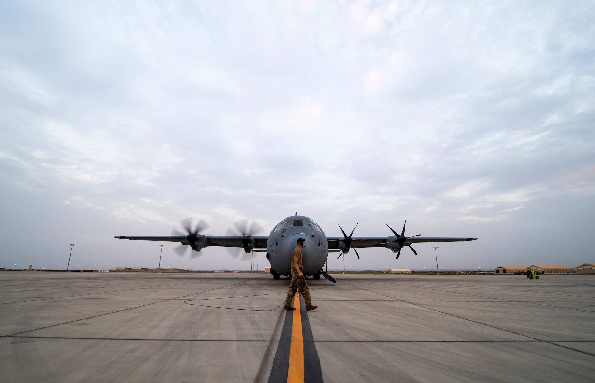 A U.S. Air Force 75th Expeditionary Airlift Squadron (EAS) loadmaster ensures engine start of a C-130J Super Hercules at Camp Lemonnier, Djibouti, June 28, 2020. The 75th EAS provides strategic airlift capabilities across the Combined Joint Task Force - Horn of Africa (CJTF-HOA) area of responsibility. (U.S. Air Force photo by Tech. Sgt. Christopher Ruano)