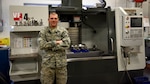 U.S. Air Force Staff Sgt. Alex Wynn, a machinist assigned to the Ohio National Guard’s 180th Fighter Wing, poses in front of a Computer Numerical Control machine at the 180FW in Swanton, Ohio, March 8, 2020. Wynn used a similar machine and knowledge he learned at the 180FW to create a replacement gear for the Wood County Courthouse clock.