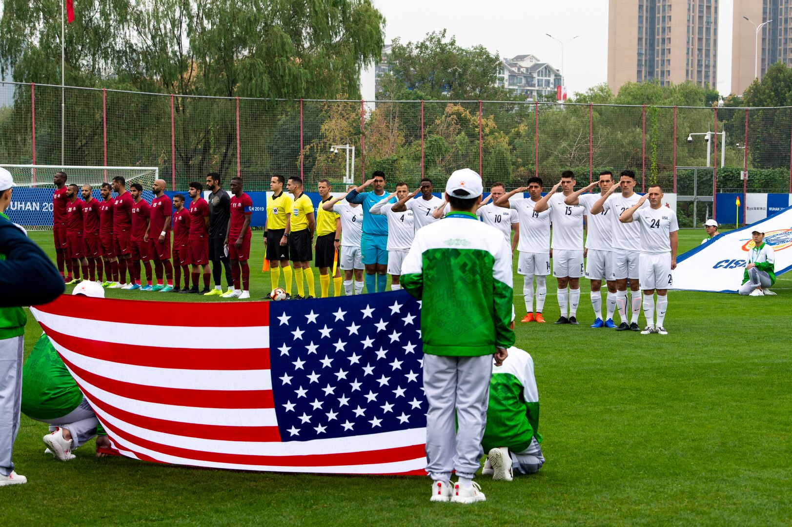 The U.S. Armed Forces Men’s Soccer Team salutes the flag during the National Anthem prior to  their match against Qatar in their first preliminary round of the CISM 2019 Military World Games in Wuhan, China Oct. 16, 2019. The Council of International Sports for the Military games open Oct. 18, 2019 and close Oct. 28, 2019. (DoD photo by Mass Communication Specialist 1st Class Ian Carver/RELEASED)