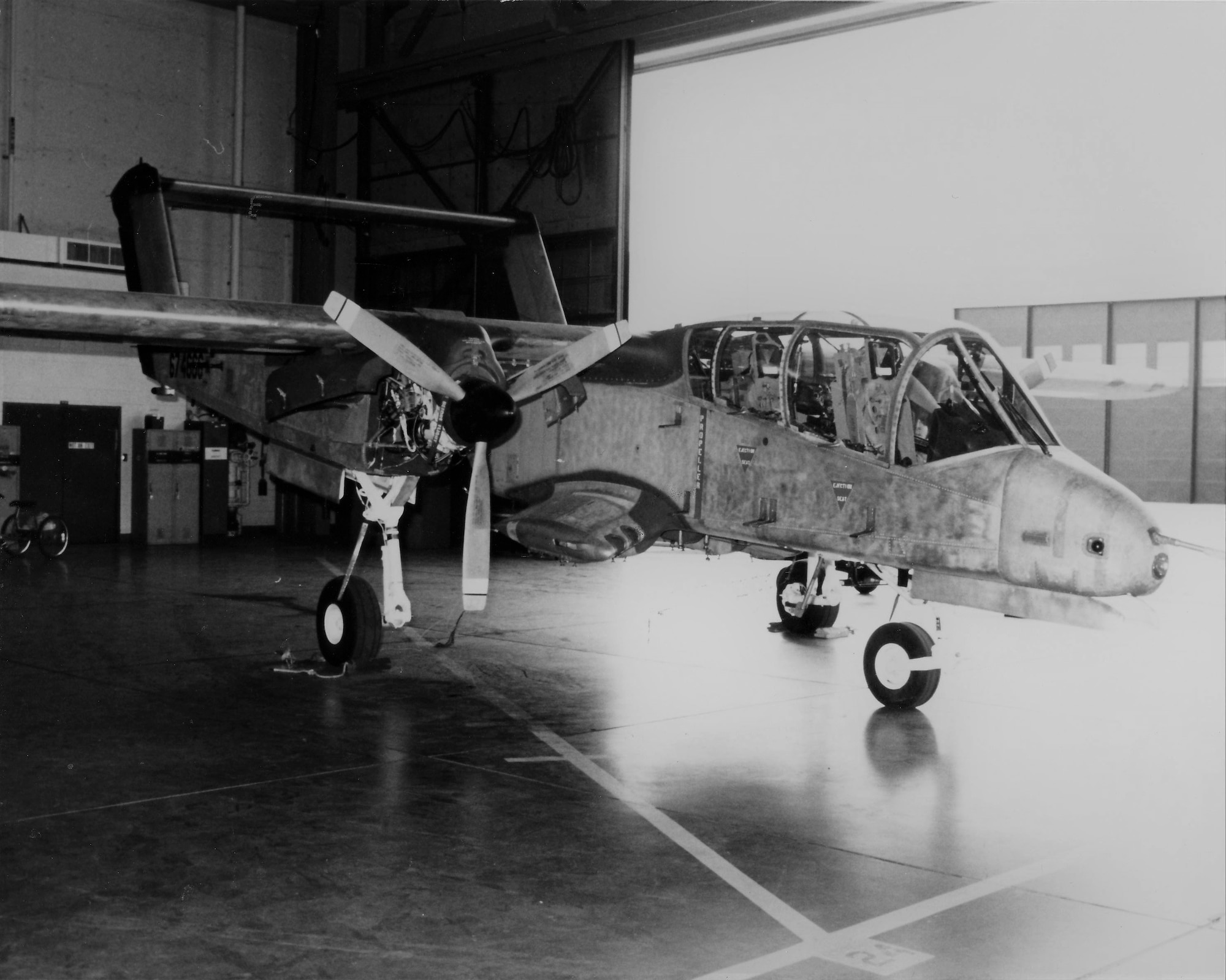 An OV-10 Bronco aircraft sits inside a hangar.