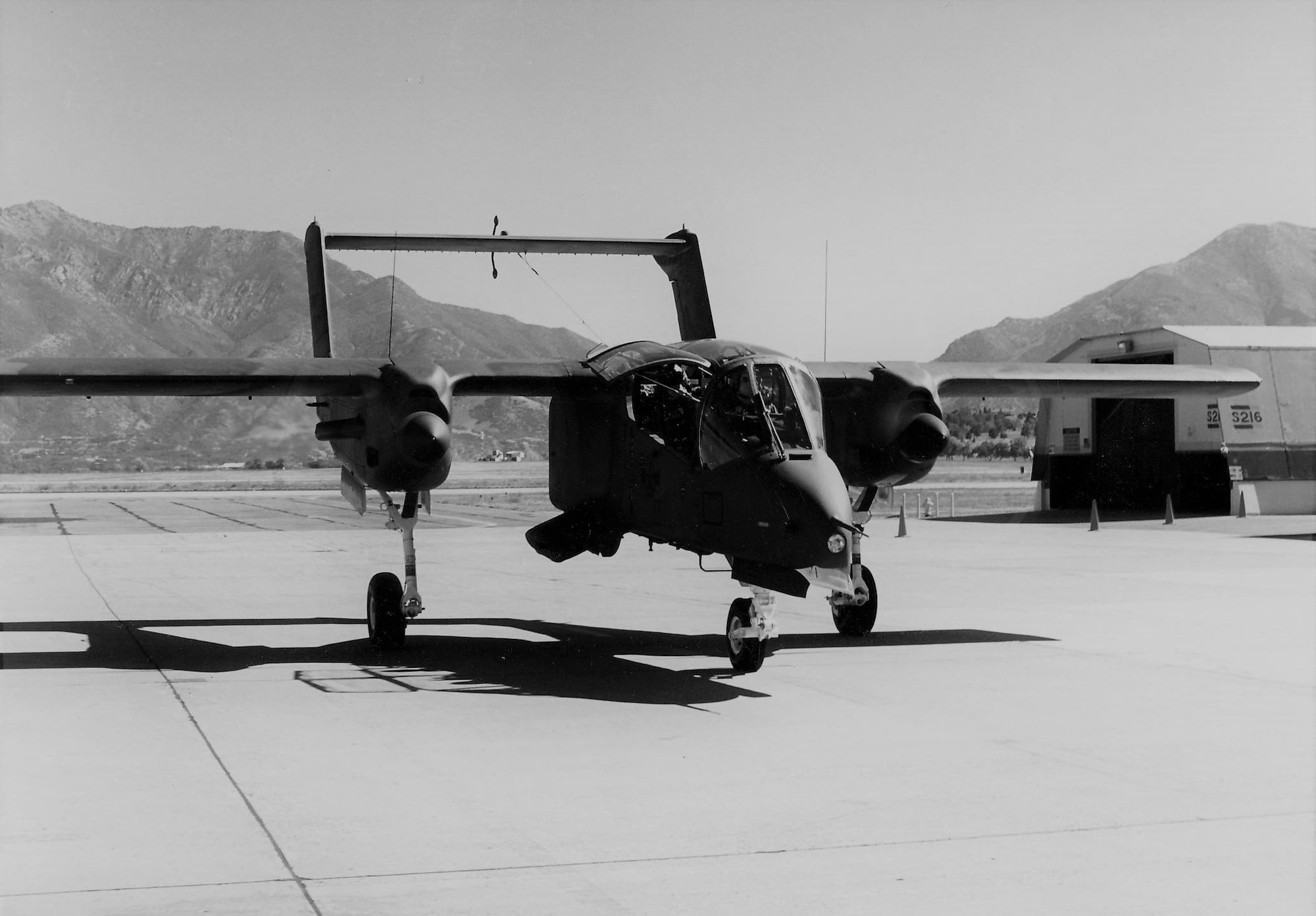 An OV-10 Bronco sits on the airfield ramp.