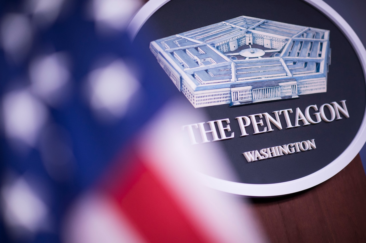 A sign that reads The Pentagon Washington sits behind the American flag.