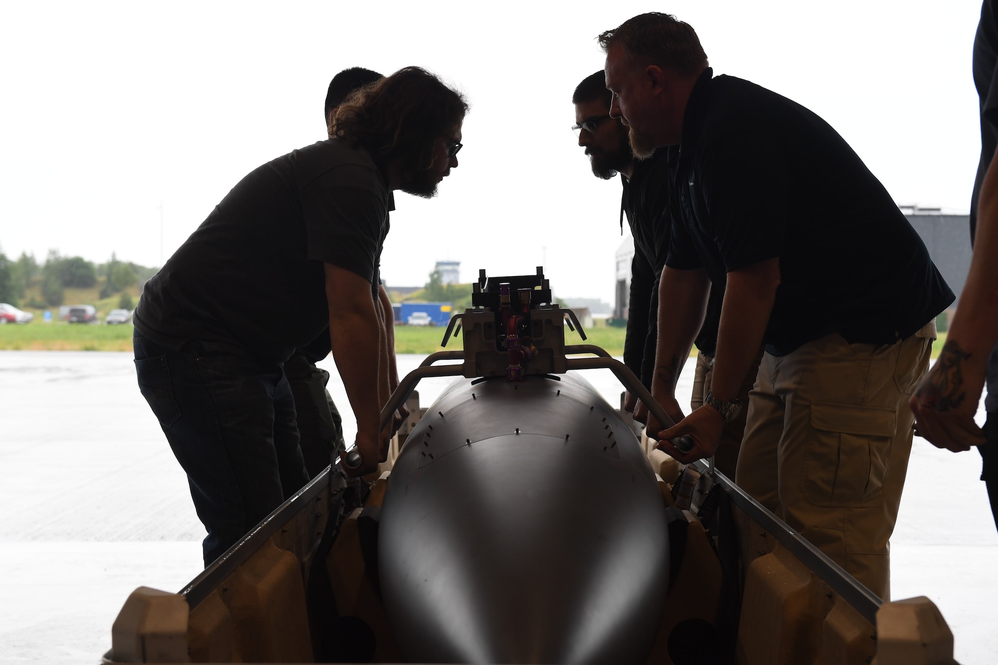 General Atomic aircraft maintenance technicians prepare to lift an MQ-9 Reaper fuel tank at Amari Air Base, Estonia, June 30, 2020. One of the aircraft was transported via cargo truck from Miroslawiec AB, where it was then offloaded and assembled in a hangar at Amari. (U.S. Air Force photo by Airman 1st Class Alison Stewart)