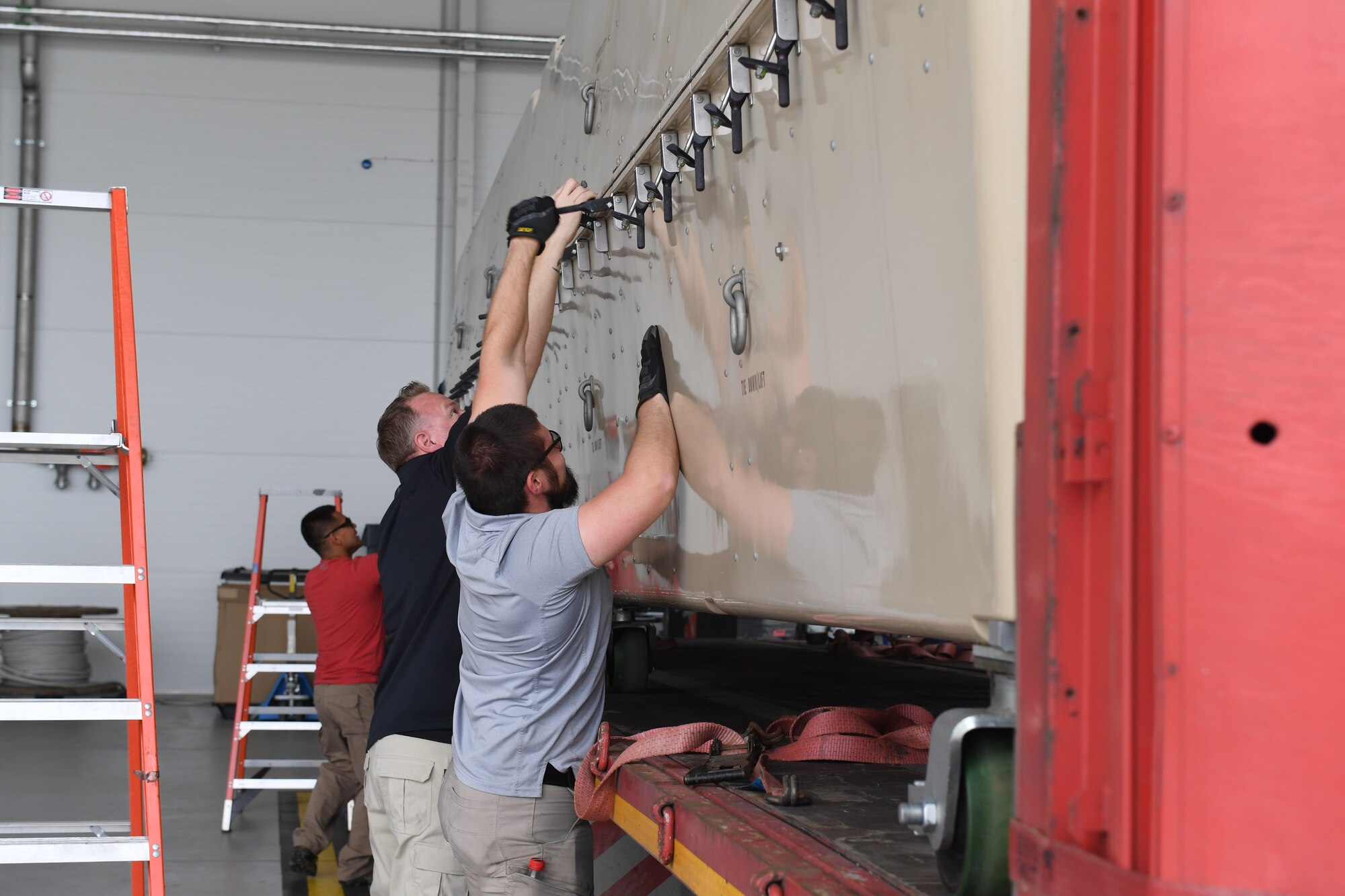 General Atomic contractors prepare to unload an MQ-9 Reaper from its container at Amari Air Base, Estonia, June 29, 2020. One of the aircraft was transported via cargo truck from Miroslawiec AB, where it was then offloaded and assembled in a hangar at Amari. (U.S. Air Force photo by Airman 1st Class Alison Stewart)