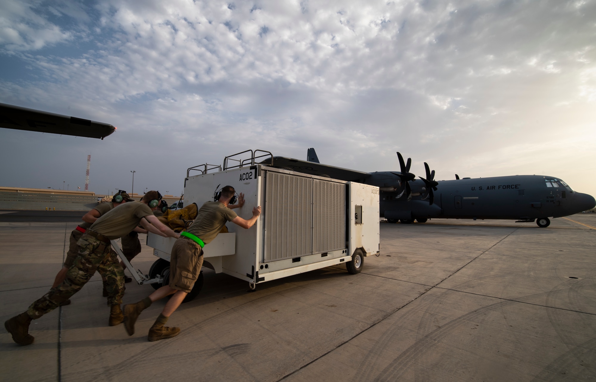 U.S. Air Force 75th Expeditionary Airlift Squadron (EAS) aircraft maintainers relocate an air conditioning unit on the flight line at Camp Lemonnier, Djibouti, June 28, 2020. The 75th EAS provides strategic airlift capabilities across the Combined Joint Task Force - Horn of Africa (CJTF-HOA) area of responsibility. (U.S. Air Force photo by Tech. Sgt. Christopher Ruano)