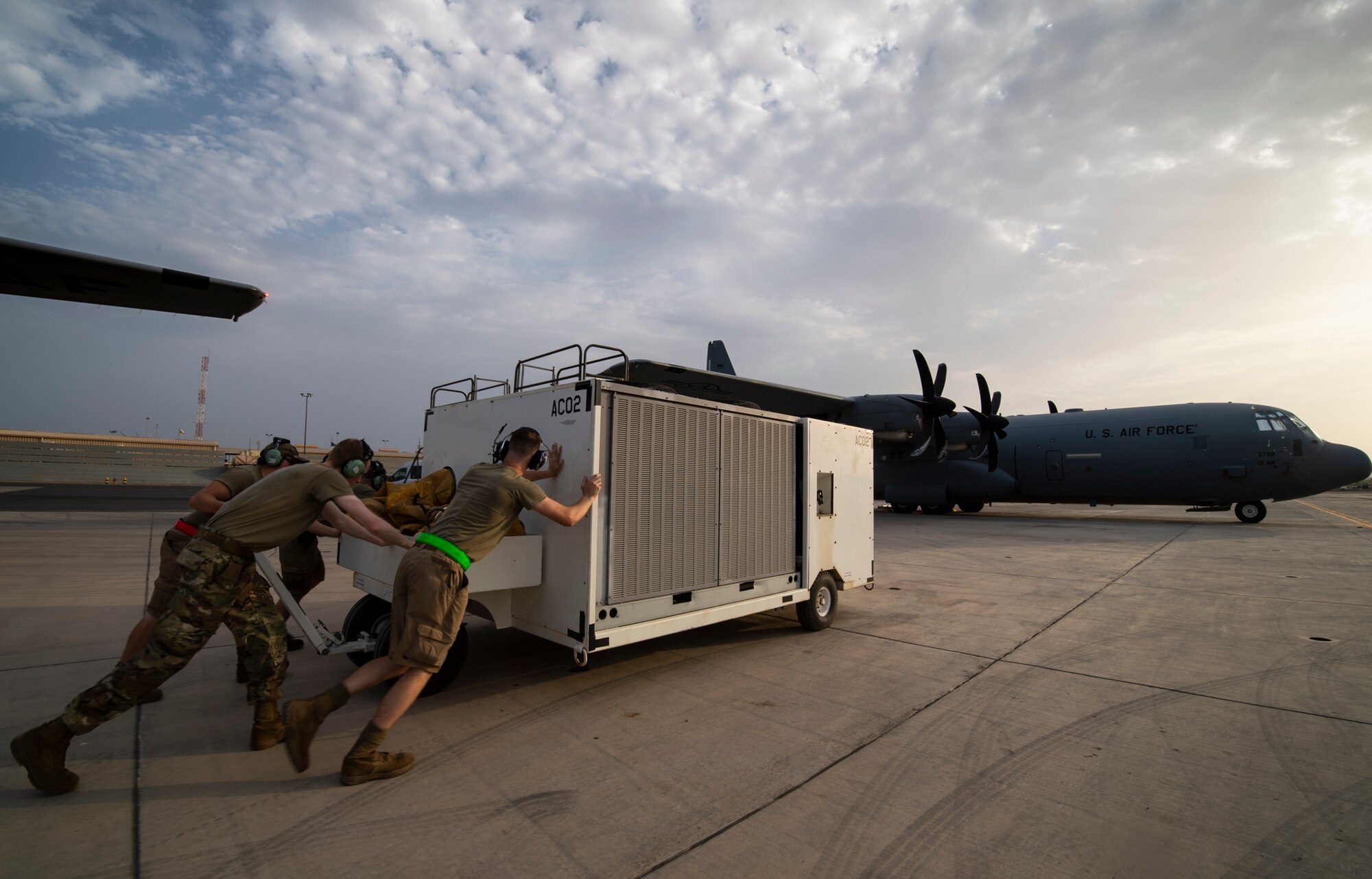 U.S. Air Force 75th Expeditionary Airlift Squadron (EAS) aircraft maintainers relocate an air conditioning unit on the flight line at Camp Lemonnier, Djibouti, June 28, 2020. The 75th EAS provides strategic airlift capabilities across the Combined Joint Task Force - Horn of Africa (CJTF-HOA) area of responsibility. (U.S. Air Force photo by Tech. Sgt. Christopher Ruano)