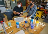 composites materials engineer in the Additive Manufacturing Project Office at Naval Surface Warfare Center Carderock Division, receives manufacturing process feedback from engineer in Carderock’s Non-Metallic Research and Engineering Branch.