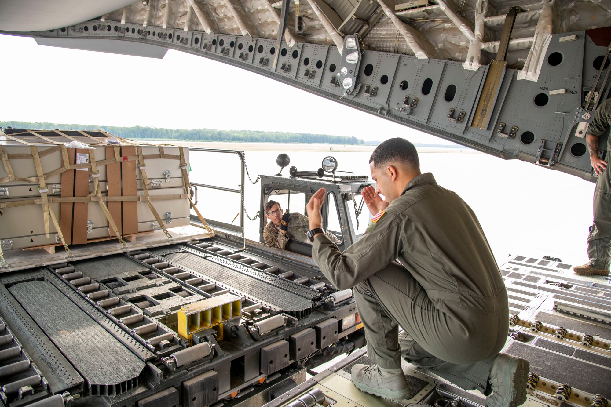 Staff Sgt. Jamal Miqbel, 3rd Airlift Squadron loadmaster, guides a K-loader carrying two empty transfer cases from Air Force Mortuary Affairs Operations which will be loaded into the back of a C-17 Globemaster III aircraft during Operation Colony Glacier, June 25, 2020, at Dover Air Force Base, Delaware. Empty transfer cases were flown from Dover to Joint Base Elmendorf-Richardson where they were used in the recovery of remains from a 1952 plane crash in southern Alaska. (U.S. Air Force photo by Tech. Sgt. Esteban Esquivel)