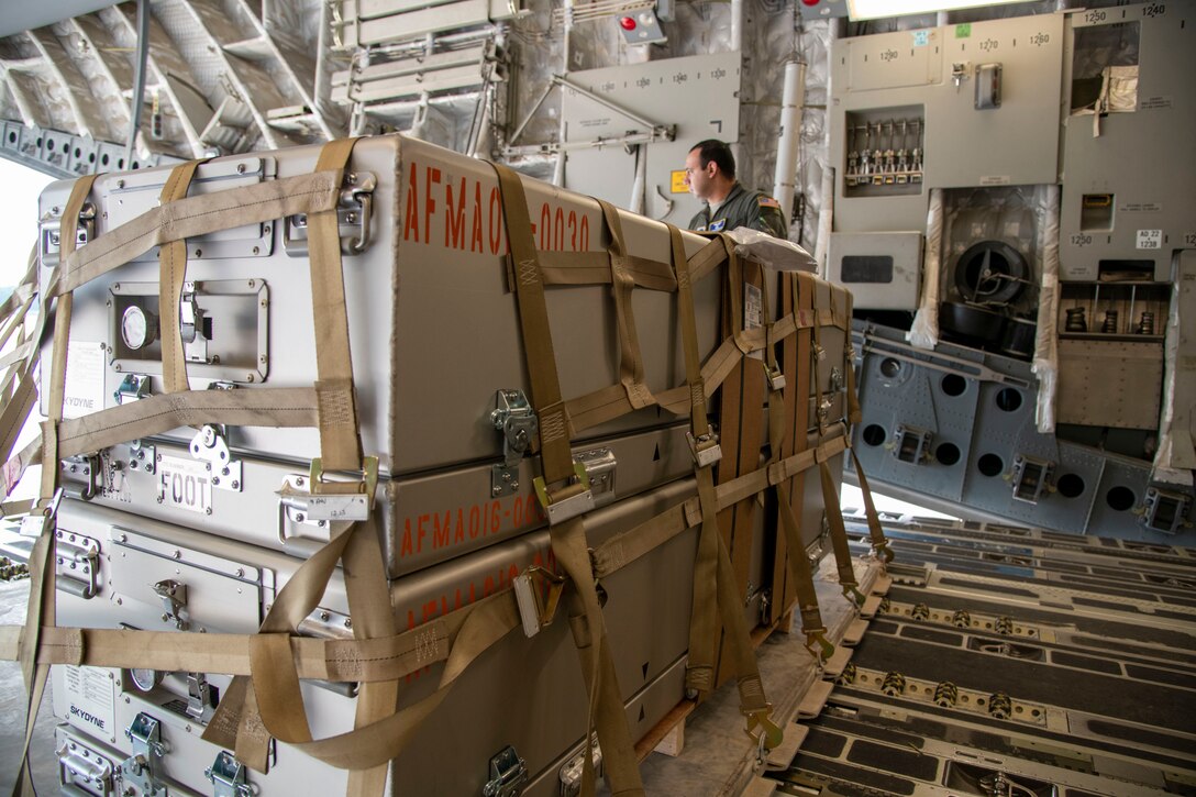 Staff Sgt. Jonathan Enriquez Colin secures empty transfer cases aboard a C-17 Globemaster III aircraft in preparation for Operation Colony Glacier, June 25, 2020, at Dover Air Force Base, Delaware. As part of the recovery effort of remains from a 1952 aircraft crash in southern Alaska, transfer cases were flown to Joint Base Elmendorf-Richardson.  Upon return to Dover, the Armed Forces Medical Examiner System begins the process of identifying any remains. (U.S. Air Force photo by Tech. Sgt. Esteban Esquivel)