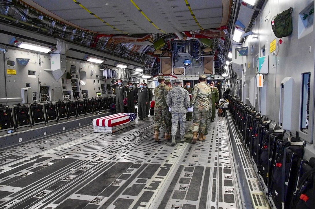 A carry team from Joint Base Elmendorf-Richardson, Alaska, transfers the remains of servicemembers recovered during Operation Colony Glacier 2020 to a Dover Air Force Base C-17 Globemaster III at Joint Base Elmendorf-Richardson, Alaska, June 29, 2020. The crew from Dover flew to JBER to bring back remains recovered during Operation Colony Glacier 2020. Operation Colony Glacier is a recovery effort of remains, personal effects, and aircraft wreckage from the crash of a C-124 Globemaster in 1952 on Colony Glacier in southern Alaska. This is the first time an Air Mobility Command aircraft has supported this mission. (U.S. Air Force Photo by Tech. Sgt. Esteban Esquivel)