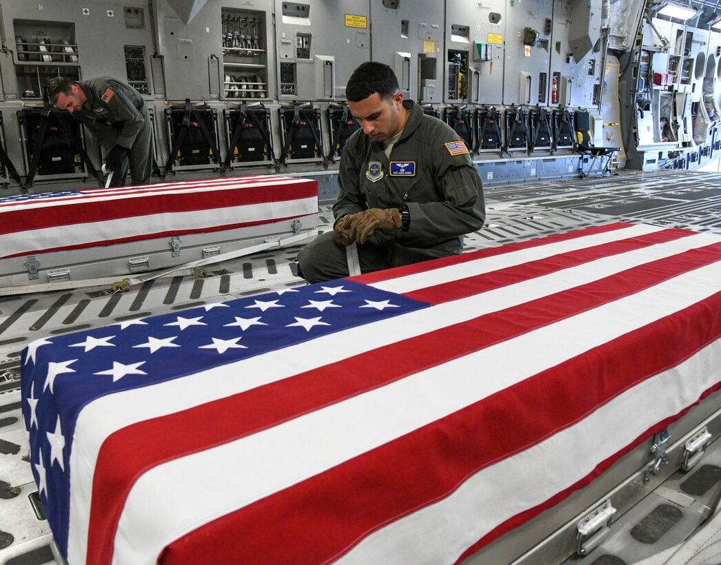 From the left, Tech. Sgt. William Jenkins and Staff Sgt. Jamal Miqbel, 3rd Airlift Squadron loadmasters, secure two transfer cases from Operation Colony Glacier at Joint Base Elmendorf-Richardson, Alaska, June 29, 2020. A C-17 Globemaster III crew from Dover Air Force Base flew to JBER to bring back remains recovered during Operation Colony Glacier 2020. Operation Colony Glacier is a recovery effort of remains, personal effects, and aircraft wreckage from the crash of a C-124 Globemaster in 1952 on Colony Glacier. This is the first time an Air Mobility Command aircraft has supported this mission. (U.S. Air Force Photo by Tech. Sgt. Esteban Esquivel)