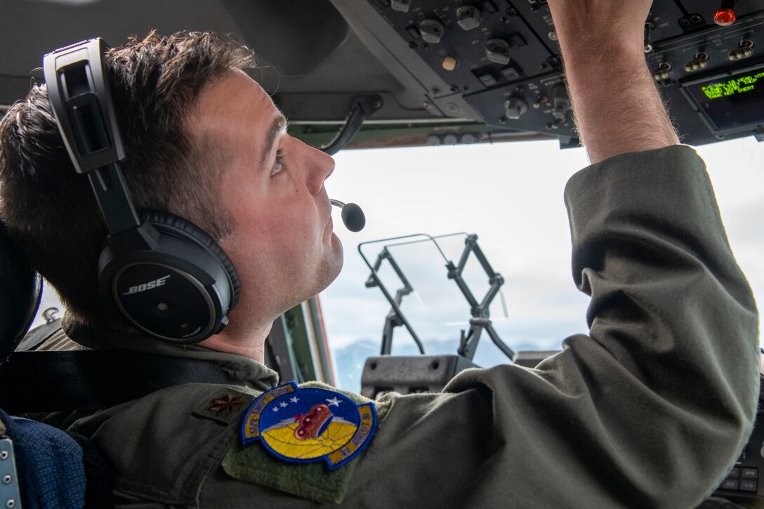 Capt. Josh Short, 3rd Airlift Squadron C-17 Globemaster III pilot, runs through preflight checks during Operation Colony Glacier, June 29, 2020, at Joint Base Elmendorf-Richardson, Alaska. A C-17 Globemaster III and crew from Dover Air Force Base flew to JBER to return remains found during Operation Colony Glacier 2020, a recovery effort of remains, personal effects and aircraft wreckage from a C-124 Globemaster II aircraft crash in 1952 on Colony Glacier. (U.S. Air Force photo by Tech. Sgt. Esteban Esquivel)