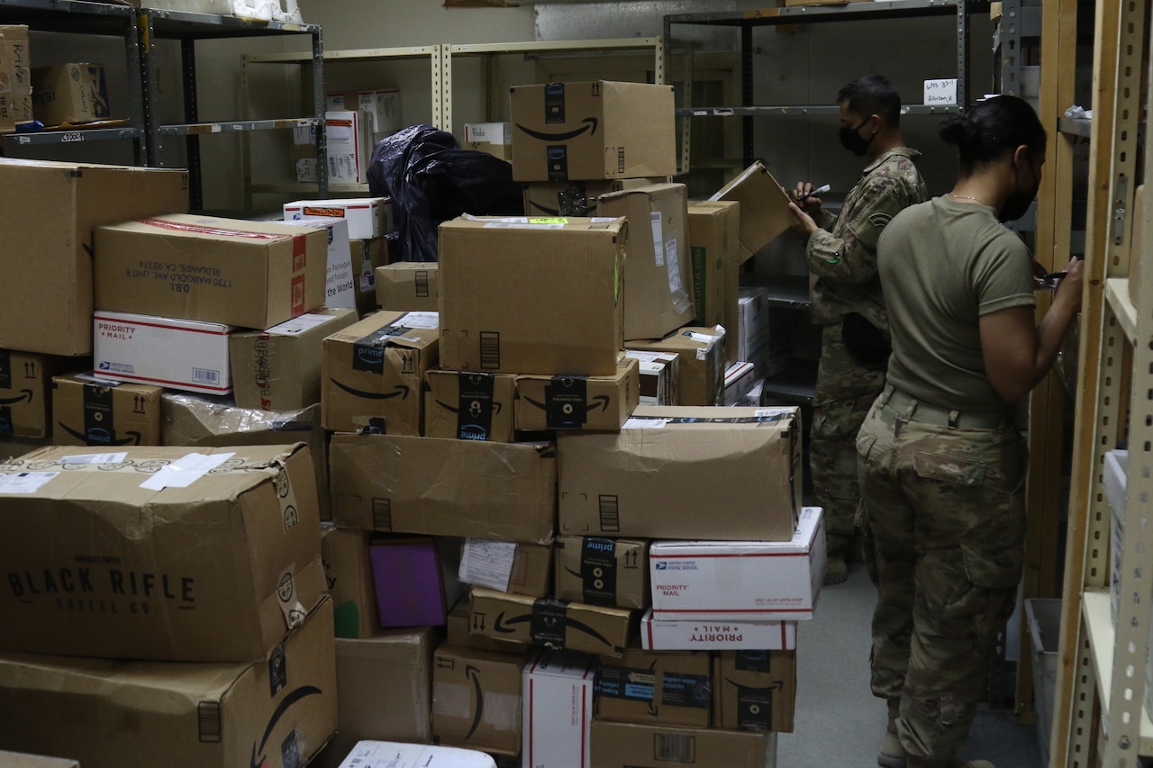 Soldiers work in a mailroom.
