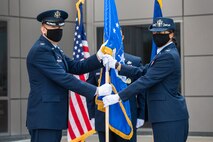 Col. James Smith, 50th Space Wing commander, left, passes the 50th Mission Support Group guidon to Col. Ericka Farmer-Hill, incoming 50th MSG commander, during a change of command ceremony July 7, 2020, at Schriever Air Force Base, Colorado. Farmer-Hill arrives at Schriever after serving as the Space and Missile Systems Center director of financial management and comptroller at Los Angeles AFB, California. (U.S. Air Force photo by Kathryn Damon)
