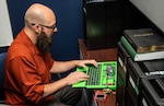 Socrates Frangis, director of Afloat Cybersecurity with the Office of Technology at NSWC PHD, performs a systems check on a prototype laptop.